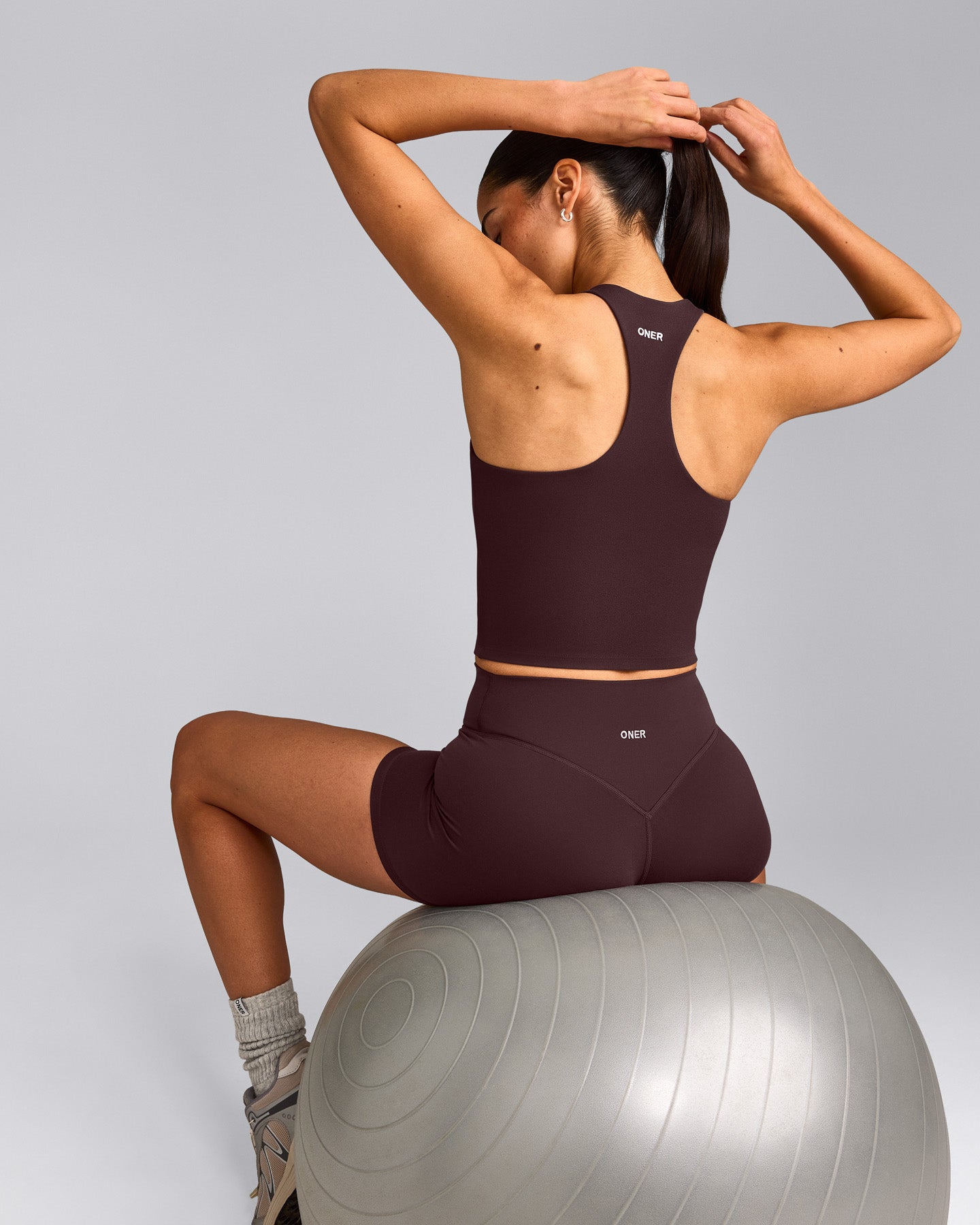 SoftMotion™ Racer Back Mid Tank Top with Built in Bra Shelf with Grey Logo | Plum Brown