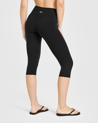SoftMotion™ High Waisted Capri Leggings with White Logo | Black