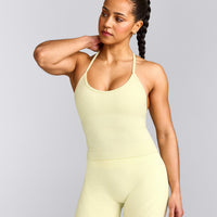 EnhanceLift™ Seamless Strappy Racer Tank Top with Built in Bra Shelf with Grey Logo | Pastel Yellow