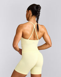 EnhanceLift™ Seamless Strappy Racer Tank Top with Built in Bra Shelf with Grey Logo | Pastel Yellow