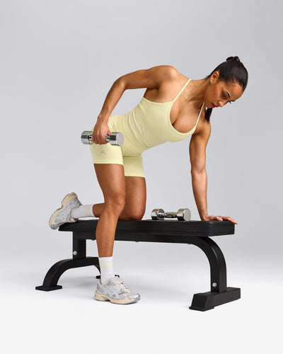 EnhanceLift™ Seamless Strappy Racer Tank Top with Built in Bra Shelf with Grey Logo | Pastel Yellow